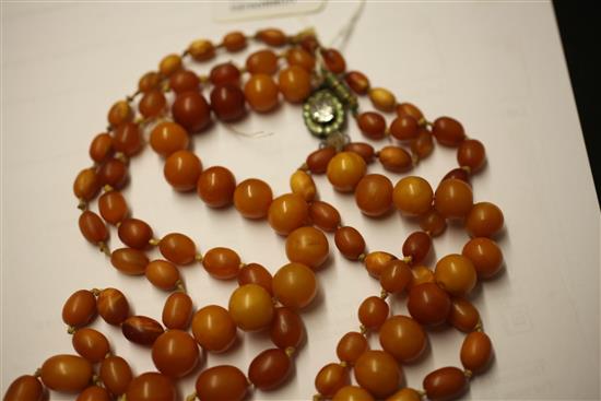 Two single strand graduated amber bead necklaces and one other round bead necklace with paste set clasp, longest 35.5in.